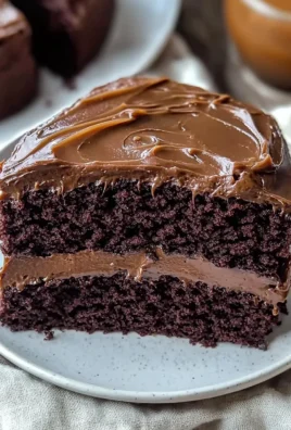 A delicious slice of chocolate fudge cake topped with decadent chocolate frosting.