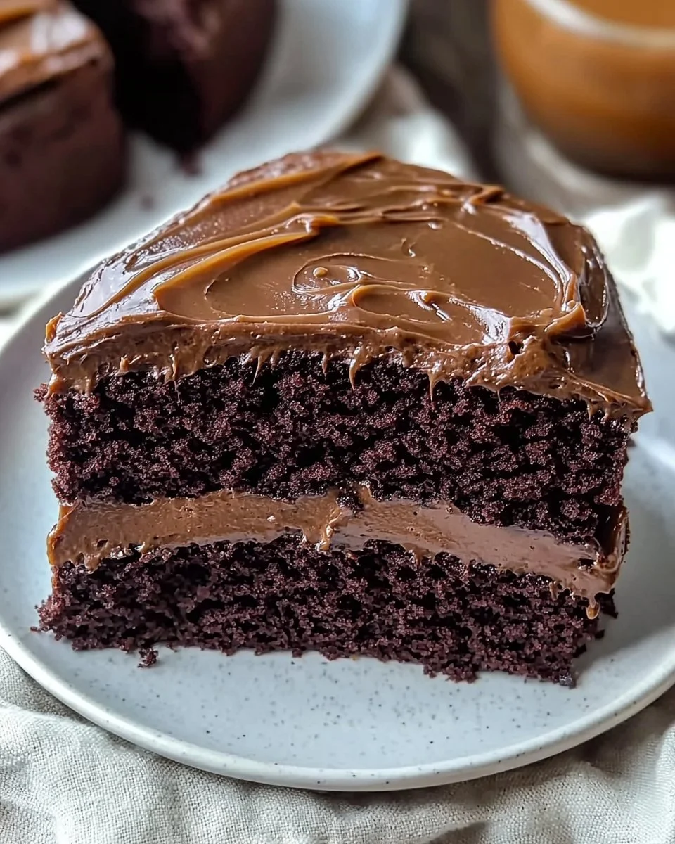 A delicious slice of chocolate fudge cake topped with decadent chocolate frosting.