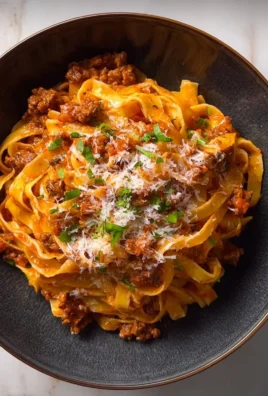 Creamy Fettuccine Bolognese with rich sauce and fresh herbs on a plate
