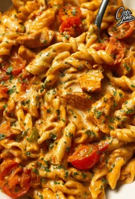 Creamy tomato chicken pasta dish with herbs and cheese