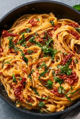 Creamy vegan sun-dried tomato pasta in a bowl, garnished with fresh basil