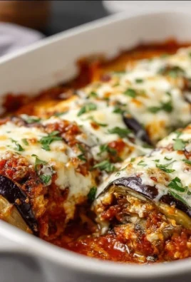 Baked Eggplant Rollatini with cheese and marinara sauce, served in a dish.