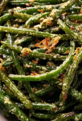Garlic Parmesan Roasted Green Beans on a plate garnished with parmesan cheese