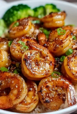 Plate of high-protein honey garlic shrimp garnished with herbs