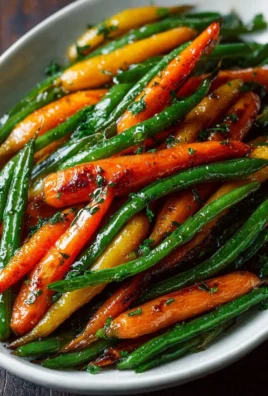 Plate of honey glazed carrots and green beans garnished with herbs
