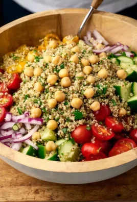 Colorful quinoa chickpea salad topped with fresh vegetables and dressing