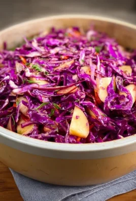 Fresh red cabbage slaw with colorful vegetables in a bowl.