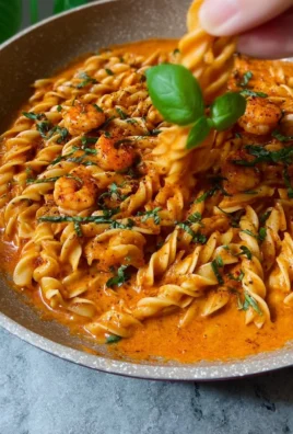 Delicious Rose Shrimp Pasta garnished with fresh herbs and served with pink sauce.