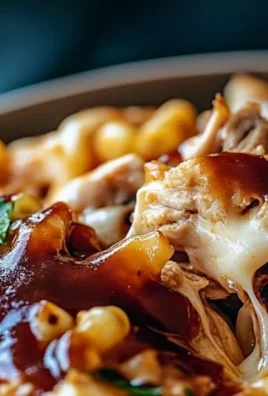Delicious bowl of shredded BBQ chicken mac and cheese topped with herbs
