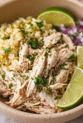 Delicious shredded slow cooker cilantro lime chicken served with fresh lime slices.