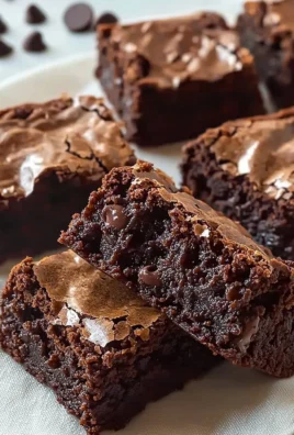 Deliciously chewy brownies topped with chocolate drizzle on a elegant plate