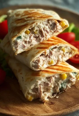 Tuna Melt Wrap with cheese and fresh vegetables on a wooden cutting board