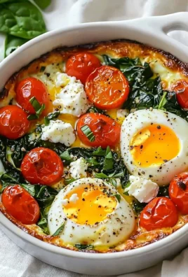 Baked feta eggs with tomatoes and spinach in a rustic dish