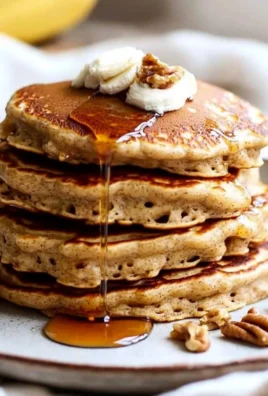 Fluffy banana bread pancakes served with syrup and banana slices
