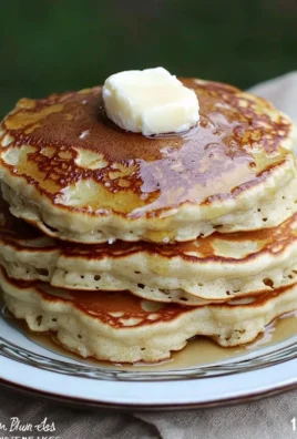 Fluffy banana pancakes topped with syrup and sliced bananas