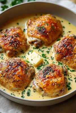 Creamy garlic chicken thighs in a skillet with herbs and sauce