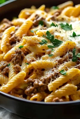 Creamy high protein beef pasta dish served in a white bowl with garnish