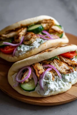 Crockpot Greek Chicken Pitas served with fresh Tzatziki sauce on a plate