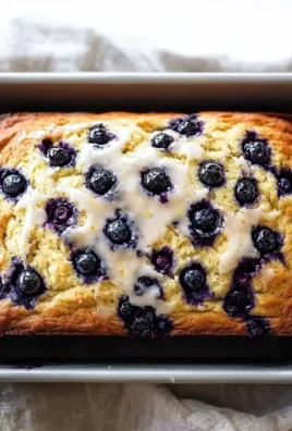 Slice of easy lemon blueberry bread with blueberries on a white plate
