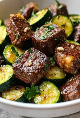 Garlic butter steak bites served on a plate with garnish.