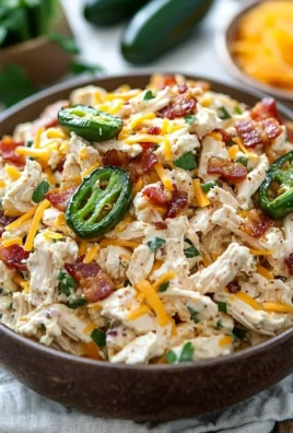 Bowl of Jalapeño Popper Keto Chicken Salad garnished with jalapeños and herbs