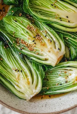 Sautéed baby bok choy in a skillet with garlic and olive oil