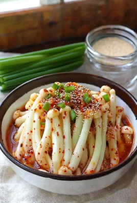 Plate of spicy enoki mushroom dish garnished with herbs