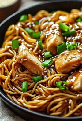 Plate of sticky garlic chicken noodles garnished with herbs