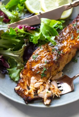Air Fryer Honey Mustard Salmon served on a plate with fresh herbs and lemon slices
