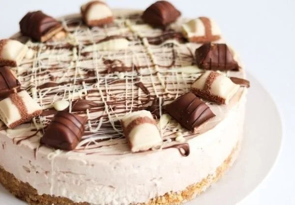Delicious Kinder Bueno no-bake cheesecake topped with chocolate and hazelnuts