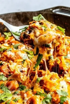 Butternut squash and black bean enchilada skillet topped with cheese and herbs