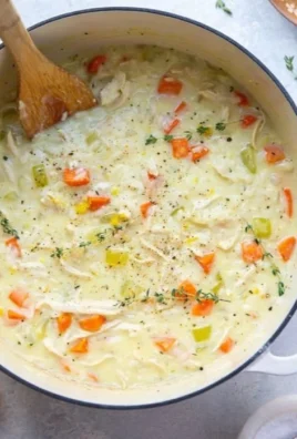 Bowl of Chicken Lemon Rice Soup garnished with lemon and herbs