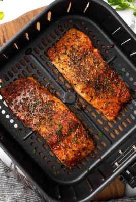 Crispy air fryer salmon garnished with herbs on a plate