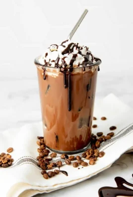 Cup of iced mocha topped with whipped cream and chocolate syrup