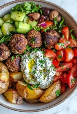 Delicious Greek Meatball Bowl topped with fresh vegetables and herbs