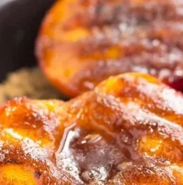 Grilled peaches topped with cinnamon and brown sugar on a plate