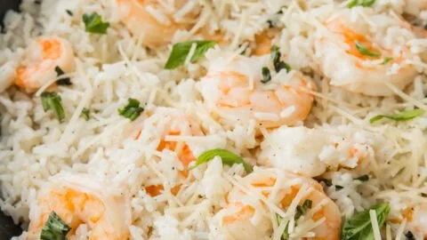 Plate of Parmesan Basil Shrimp with rice garnished with fresh basil