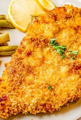 Delicious air fryer fried chicken served on a plate with fresh herbs.