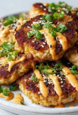 Plate of Asian tuna cakes garnished with herbs and spices