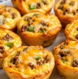 A variety of colorful breakfast pies filled with eggs, cheese, and vegetables.