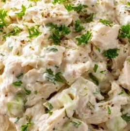 Delicious chicken salad in a bowl garnished with herbs and vegetables