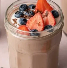 Delicious chocolate protein pudding in a bowl, topped with chocolate shavings.