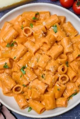Bowl of creamy tomato pasta sauce with pasta and fresh ingredients
