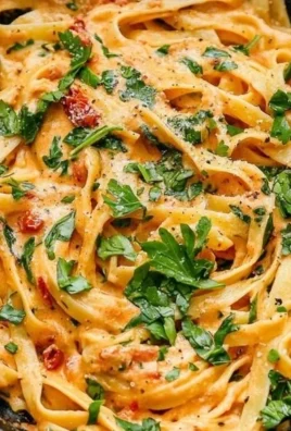 Creamy vegan sun-dried tomato pasta served in a bowl with fresh herbs