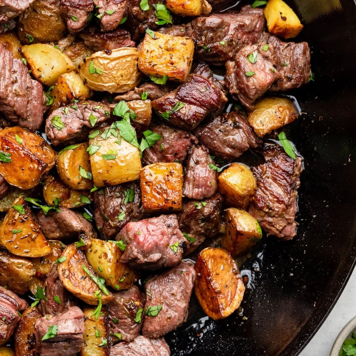 Garlic Butter Steak Bites with crispy potatoes on a plate