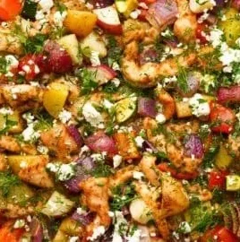 Greek sheet pan chicken with roasted veggies on a serving platter