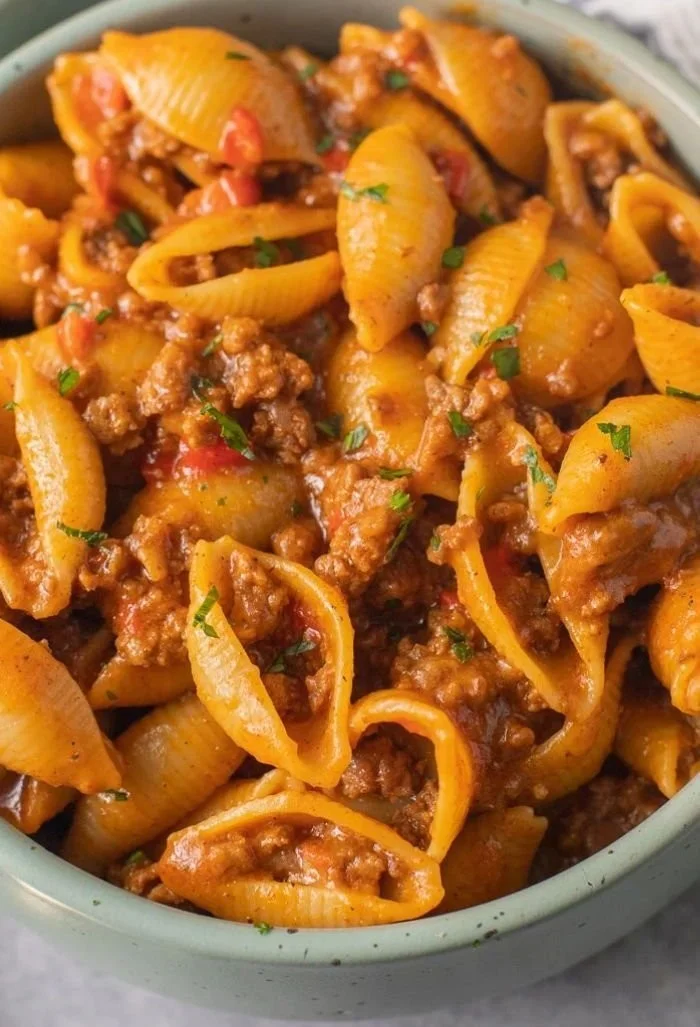 High protein taco pasta served in a bowl with toppings including cheese and cilantro