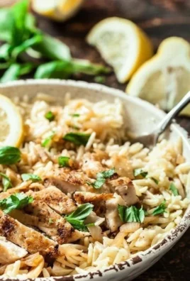 Delicious Lemon Basil Orzo with Chicken garnished with fresh basil leaves.