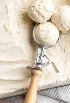 No churn vanilla ice cream with strawberry jam and toasted peanuts topping