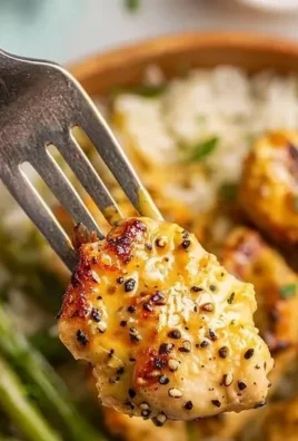 Bowl of honey mustard chicken with vegetables and grains on a rustic table